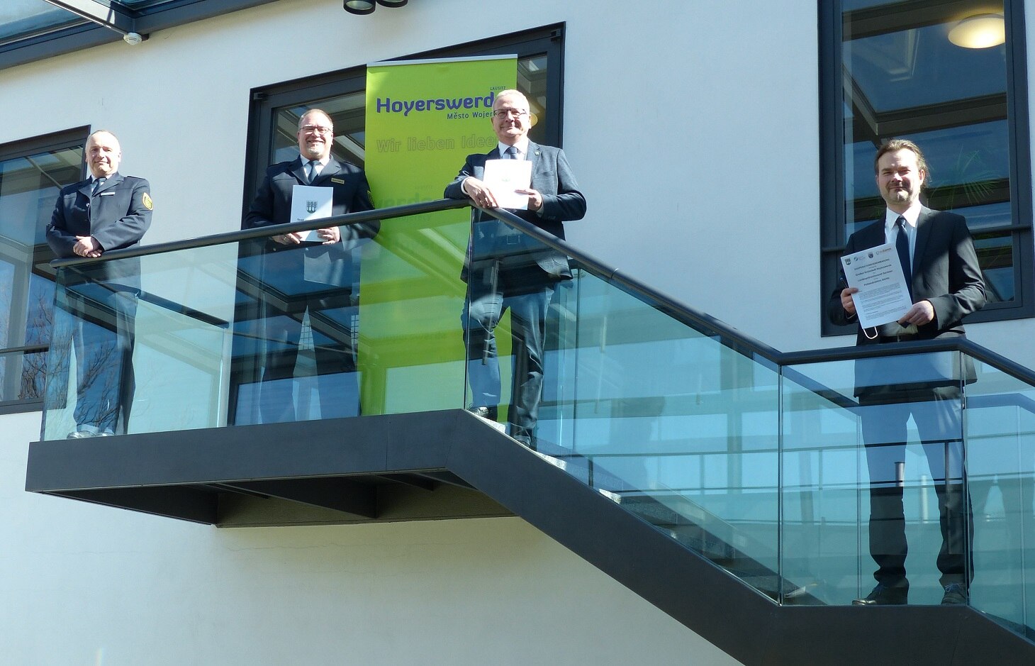 Die Unterzeichner der Kooperationsvereinbarung stehen auf der Treppe vor der Stadtverwaltung Hoyerswerda.