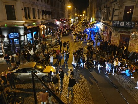 Auf dem Bild ist die Schiefe Ecke Dresden-Neustadts bei Nacht mit Partygästen zu erkennen.