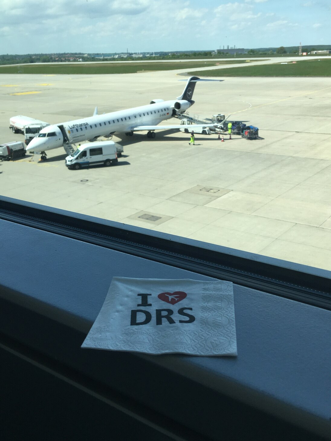 Flugzeug auf der Landebahn und im Vordergrund eine Serviette auf der I Love Dresden steht
