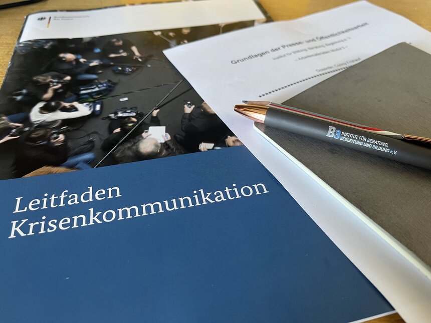 Das Titelbild des Leitfaden für Krisenkommunikation wird gezeigt. Es besteht aus einem blauen Hintergrund mit weißer Schrift.