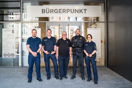 Fünf Menschen stehen vor einem Gebäude an dem der Name "Bürgerprunkt" steht.