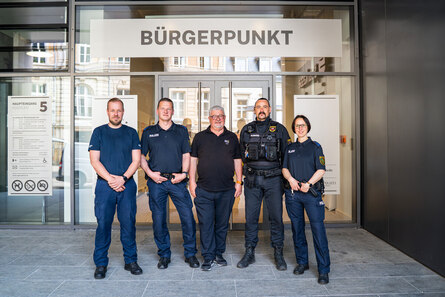 Fünf Menschen stehen vor einem Gebäude an dem der Name "Bürgerprunkt" steht.