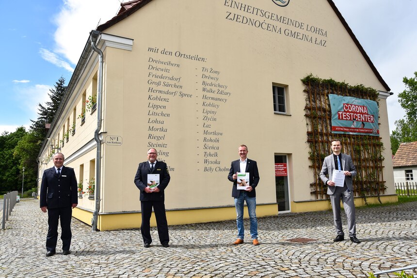 Vier Personen stehen vor dem Haus der Einheitsgemeinde Lohsa.