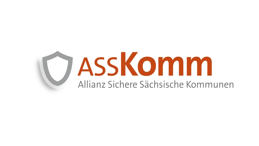 Das Wort ASSKomm als Schriftzug in orange.