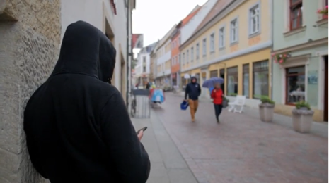 Ein Mann steht in einem Hauseingang und wartet auf Opfer.