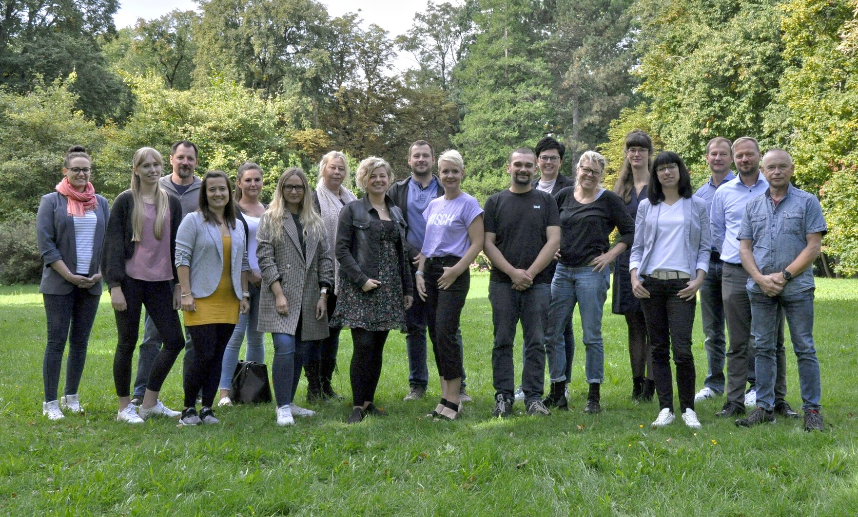 Bild zeigt die Teilnehmer auf einer Wiese für ein Gruppenfoto 