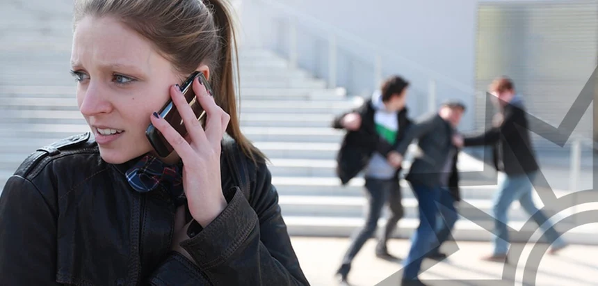 junge Frau telefoniert vor einer Treppe mit einem ängstlichenGesichtsausdruck