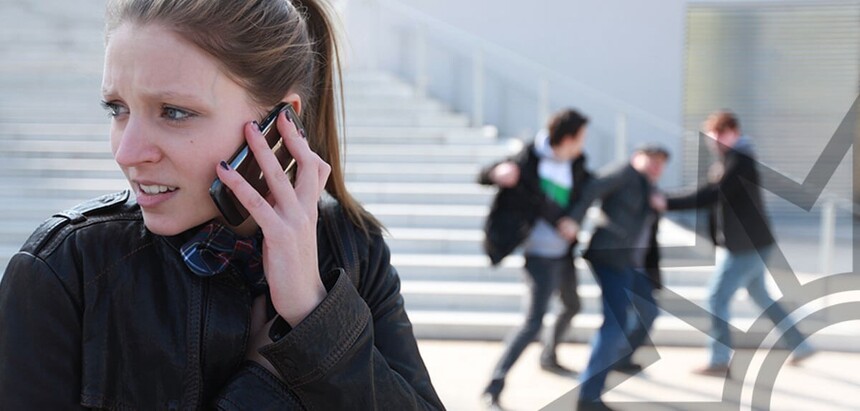 junge Frau telefoniert vor einer Treppe mit einem ängstlichenGesichtsausdruck