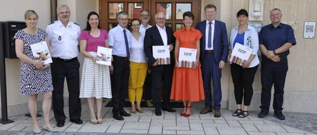 Alle Teilnehmer an der Unterzeichnung der Kooperationsveranstaltung stehen vor dem Rodewischer Rathaus. Die Unterzeichner halten ein Buch bzw. eine LPR-Mappe in den Händen.