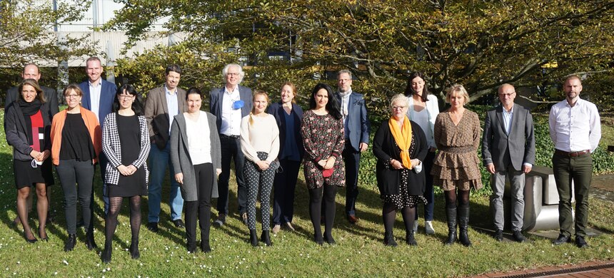 Alle Teilnehmer der Tagung stehen für das Gruppenfoto vor einem Gebäude. 