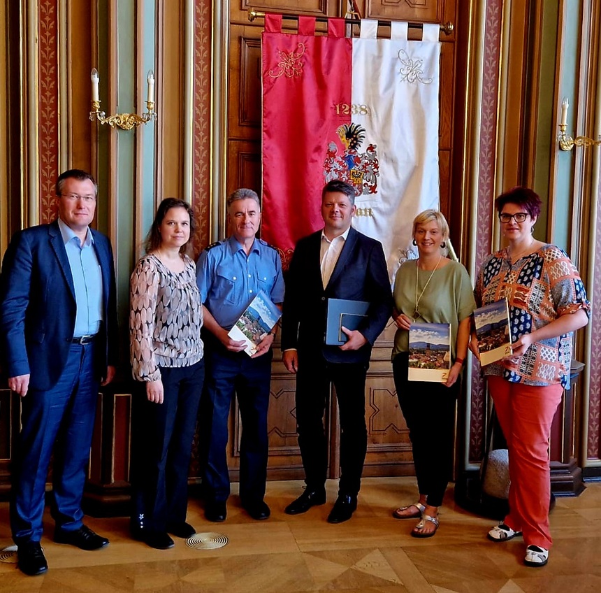 Sechs Personen stehen vor der Fahne der Stadt Zittau.