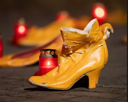 Ein Damenschuh steht auf der Straße und daneben ein rotes Licht.