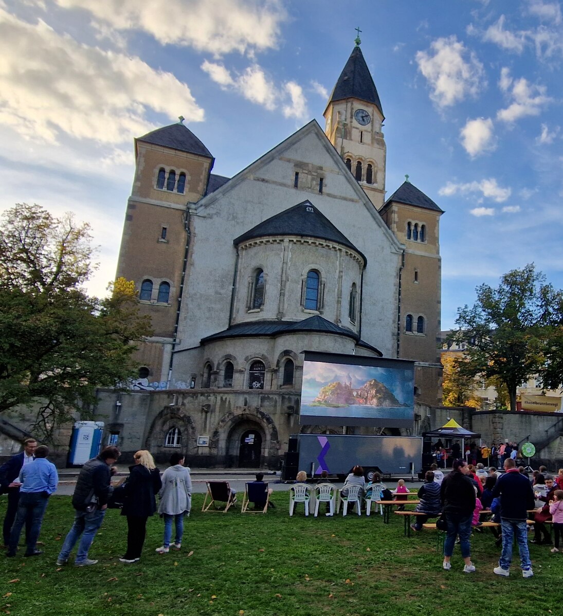 Kirche mit Filmleinwand und Zuschauern.