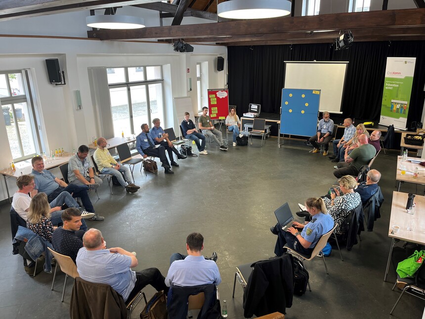 zeigt Teilnehmer im Saal bei einer Besprechung 