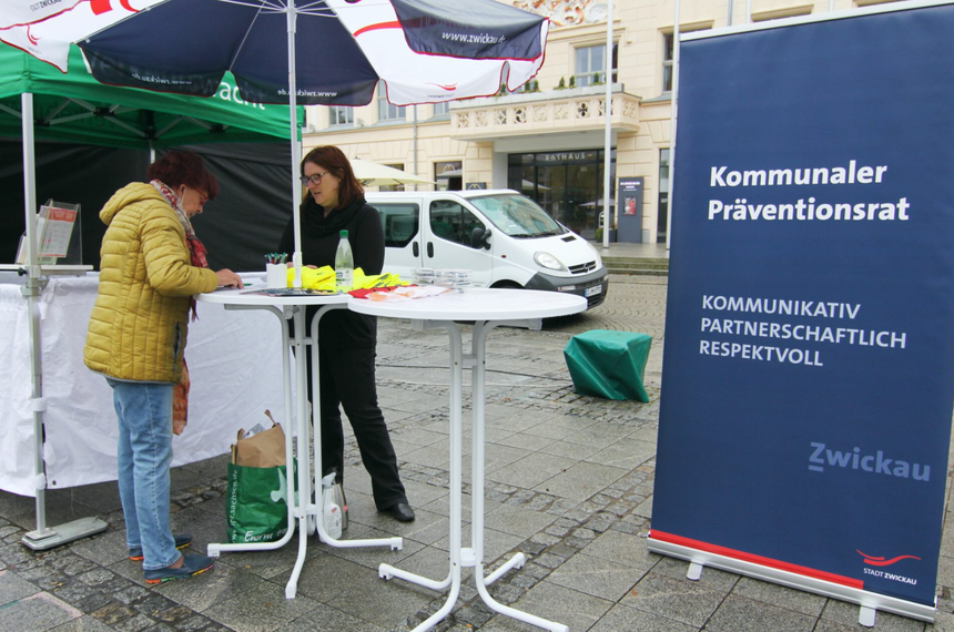 Bild zeigt zwei Frauen an zwei Stehtischen unter einem Schirm am Stand des Kommunalen Präventionsrat Zwickau